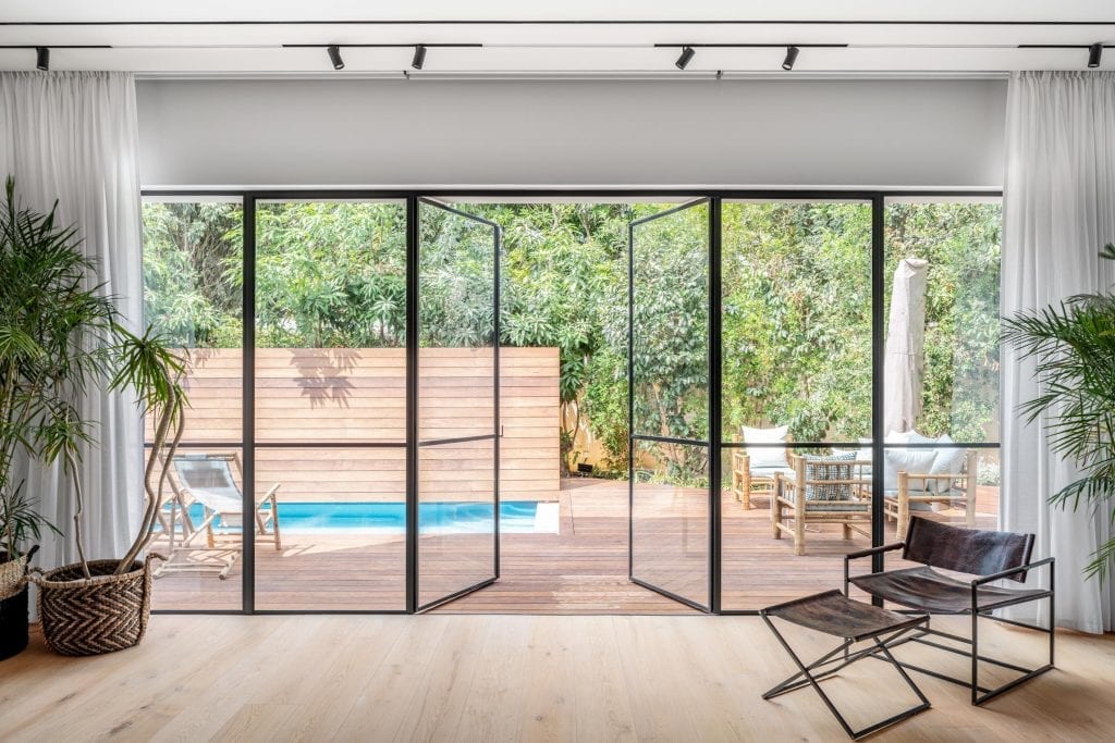 חלונות ברזל מעוצבים עם פרופיל ברזל דקיק מינימליסטי ופתיחה בקיפול לפתיחה מקסימלית לגינה ולבריכה