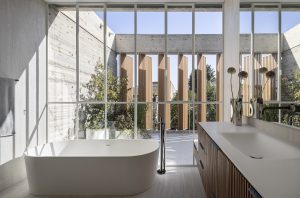 W20 Slim System ultra slim steel windows frame a modern bathroom with a soaking tub and vanity.