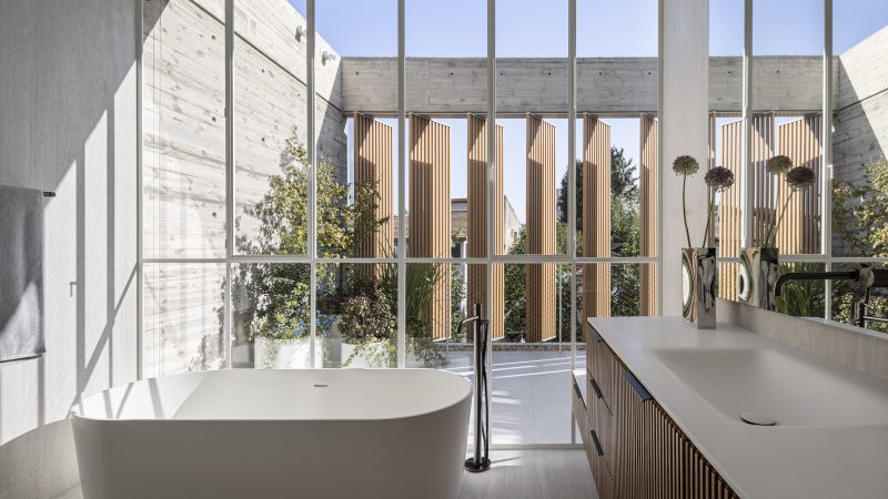 W20 Slim System ultra slim steel windows frame a modern bathroom with a soaking tub and vanity.